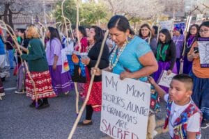 a picture showing a gathering of indigenous people of america holding protest signs