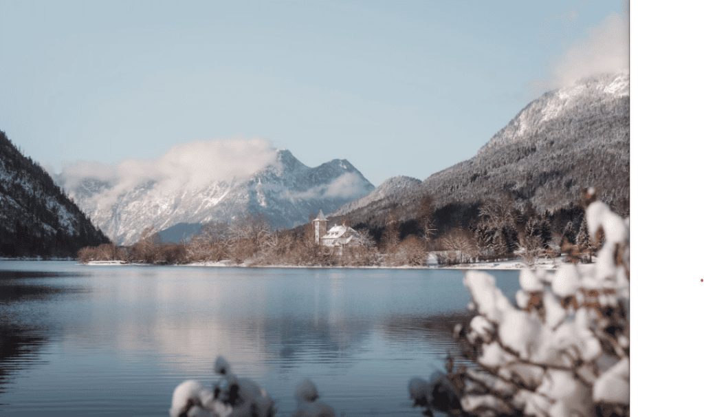 Snowy alpine lake with small white church