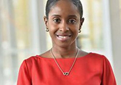 A woman in a red top smiling for the camera.