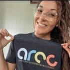 A woman holding up a t - shirt that says arcc.