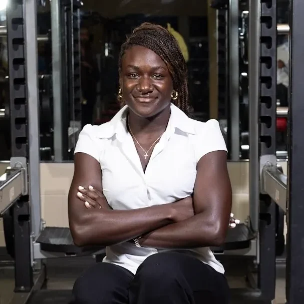 Smiling woman sitting in a gym setting.