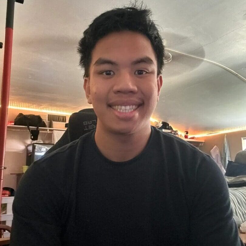 Smiling person sitting in a room.